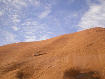 Scenic view of desert against cloudy sky