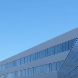 Low angle view of modern building against clear blue sky