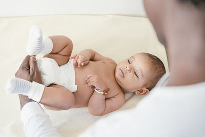 High angle view of father carrying shirtless baby girl