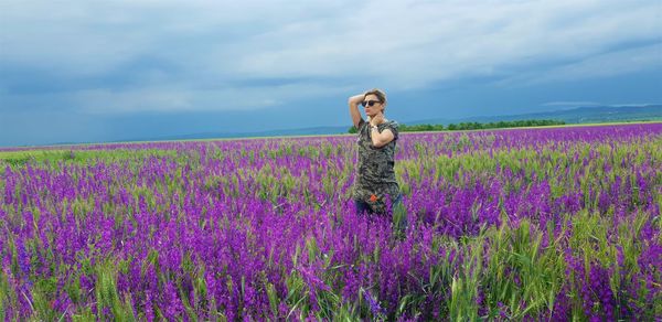 Woman standing amidst purple flowers on land