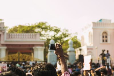 Group of people photographing against sky