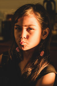 Close-up portrait of girl pouting at home