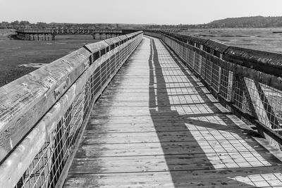 View of wooden walkway leading towards water