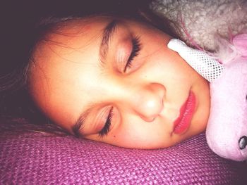 Close-up of girl sleeping on bed at home