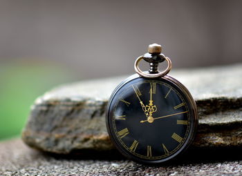 Close-up of vintage clock on rock