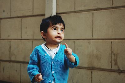 Smiling girl standing against wall