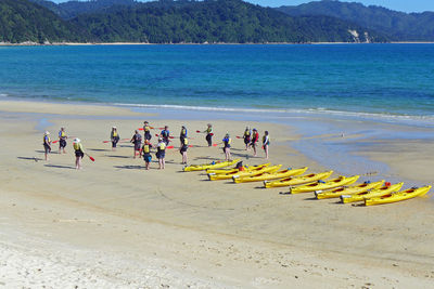 People enjoying at beach against sky