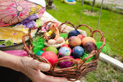 Midsection of person holding multi colored basket