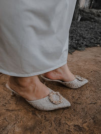 Low section of woman standing on footpath