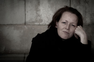 Portrait of woman against wall outdoors