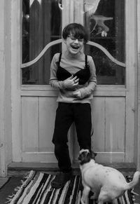 Portrait of smiling kid standing against door