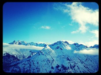 Scenic view of mountain range against cloudy sky