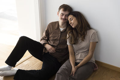 Relaxed multiracial couple sitting with eyes closed at home
