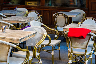 Empty chairs and tables at sidewalk cafe