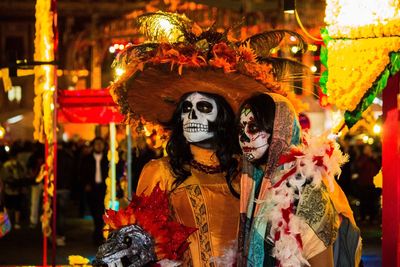 Close-up of people with spooky make-up at night during carnival