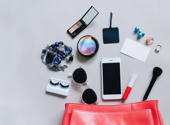 Directly above shot of smart phone with beauty products on table