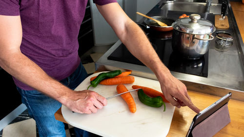 On-line cooking lessons through a tablet, preparing to cut vegetables