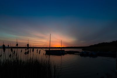 Silhouette sailboats in sea against sky during sunset