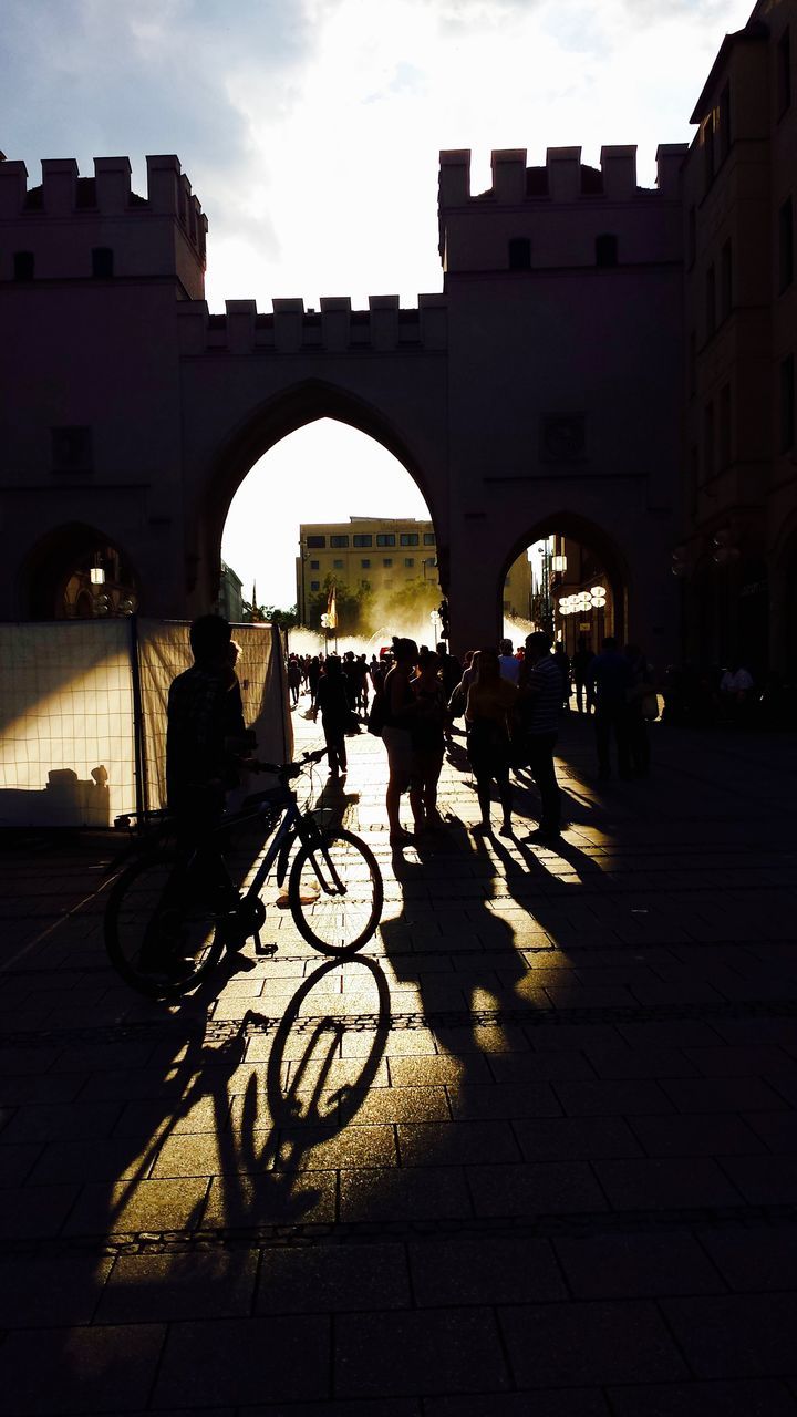 SIDE VIEW OF SILHOUETTE PEOPLE WALKING ON STREET BY ARCH BRIDGE