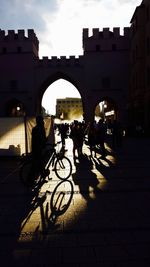 Side view of silhouette people walking on street against sky