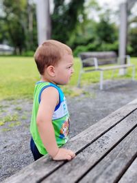 Side view of cute boy on wood