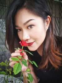 Portrait of beautiful woman with red flower
