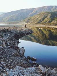 Reflection of rocks in lake against sky