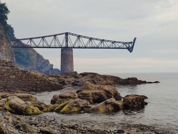 Low angle view of bridge over sea against sky