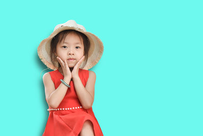 Portrait of cute girl wearing hat against blue background