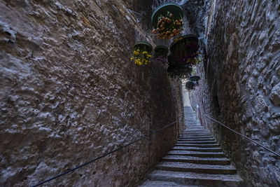 Narrow pathway amidst walls in tunnel