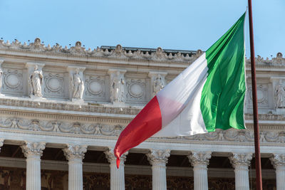 Italian flag in front of fatherland from piazza venezia in rome known as monument to victor emmanuel