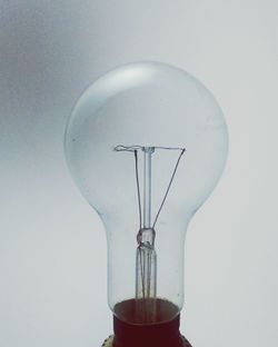 Close-up of light bulb against white background