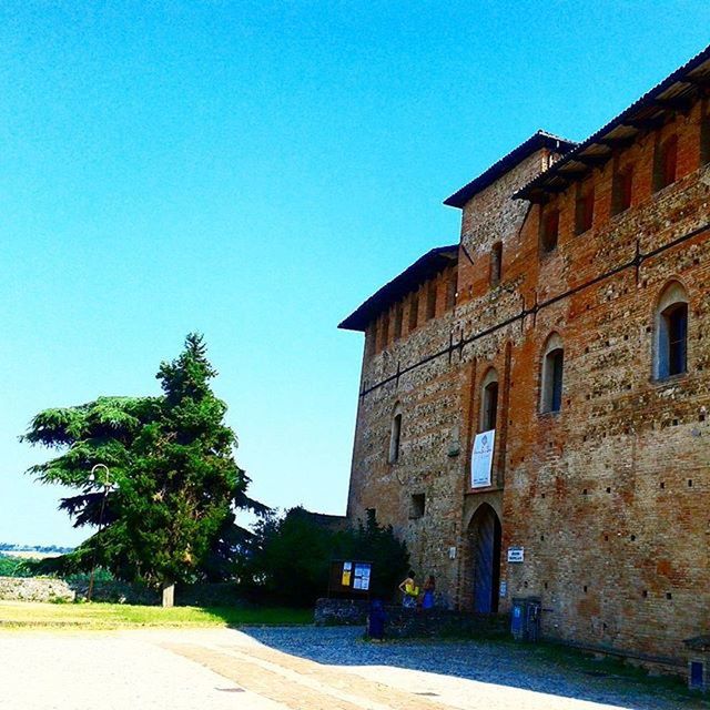 architecture, built structure, clear sky, building exterior, blue, copy space, house, sunlight, low angle view, tree, history, old, day, residential structure, building, shadow, outdoors, road, street, no people