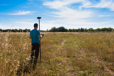 Surveyor working with a gps instrument, taking data from the surface