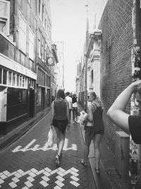 Rear view of people walking on city street