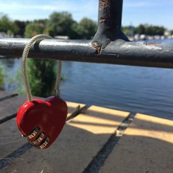 Close-up of red metal hanging on railing against river