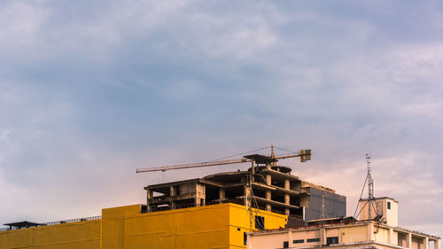 Construction site with tower crane on blue sky with clouds background.