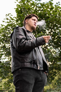 Low angle view of man standing against trees