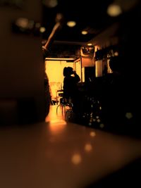 Silhouette people in illuminated room
