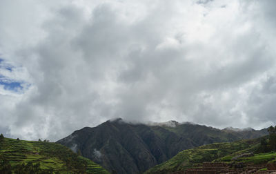 Scenic view of rocky mountains against cloudy sky