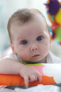 Cute newborn baby girl looking serious at camera. big blue eyes staring