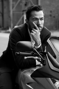 Portrait of young man sitting on car