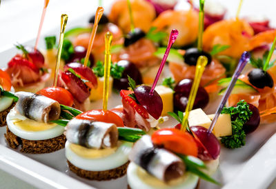 Close-up of various seafood and meat canapes over white background