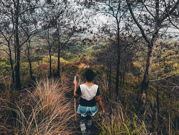 Rear view of woman walking in forest