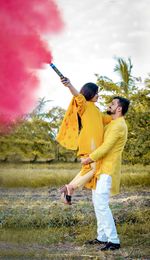 Couple standing on field against sky