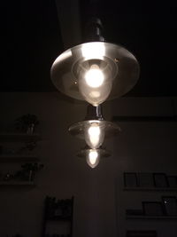 Low angle view of illuminated lamp hanging at night