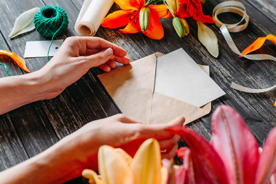 High angle view of woman hand holding red flower