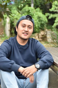 Portrait of smiling young man sitting outdoors