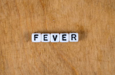 Close-up of sign board on wooden table