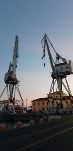 Cranes at construction site against clear sky